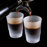 Two frosted translucent coffee cups with Binco branding, shown on a black espresso machine with espresso being poured into them. The Binco logo is also visible as an overlay in the top left.