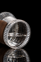 Close-up of a glass container with a wooden handle on a light gray background