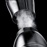 A close-up promotional shot of a metallic steam dryer component with visible steam escaping from the center opening, set against a dark textured background with marketing text about water vapor separator and strong steam.