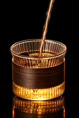 Glass mug with wooden and metallic base on a gray background