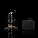 Product information graphic showing a manual espresso maker with a glass cup and a black carrying case, with dimension labels for height, width, and depth.