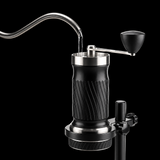 Manual coffee grinder with a black ribbed body and silver metal accents, shown with text explaining temperature-controlled water extraction on a light gray background.